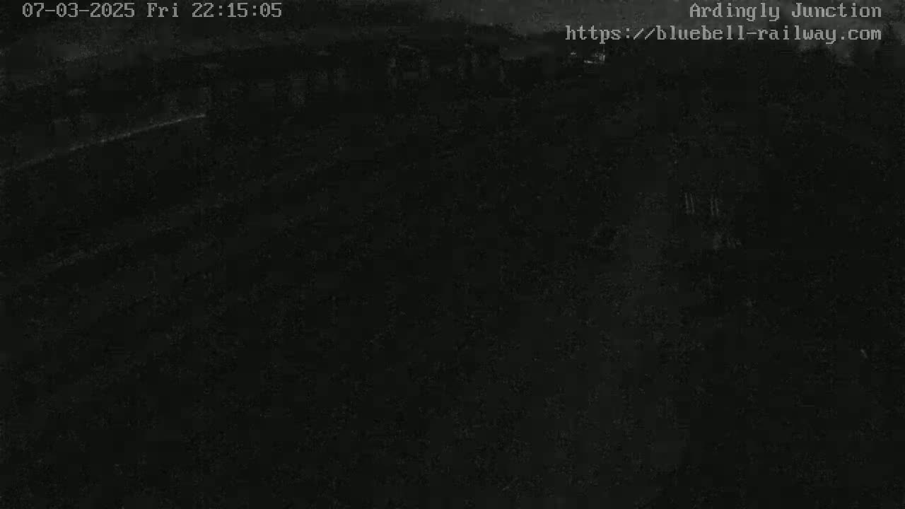 A dark, nighttime image shows a mostly black scene with some faint lighter areas.