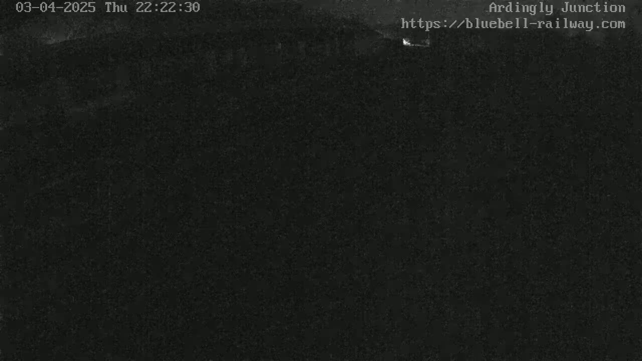 A nighttime, low-light outdoor scene shows a dark, mostly featureless expanse.