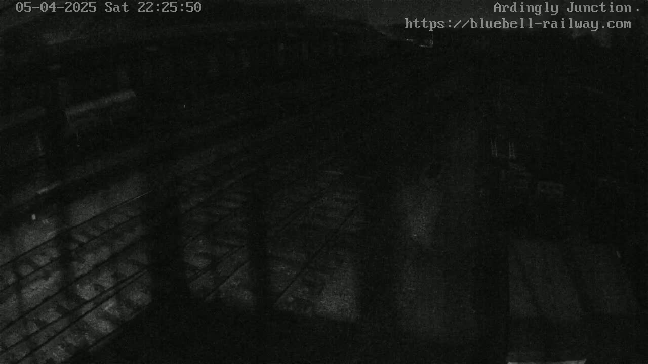 A nighttime, low-light view of a train track area.