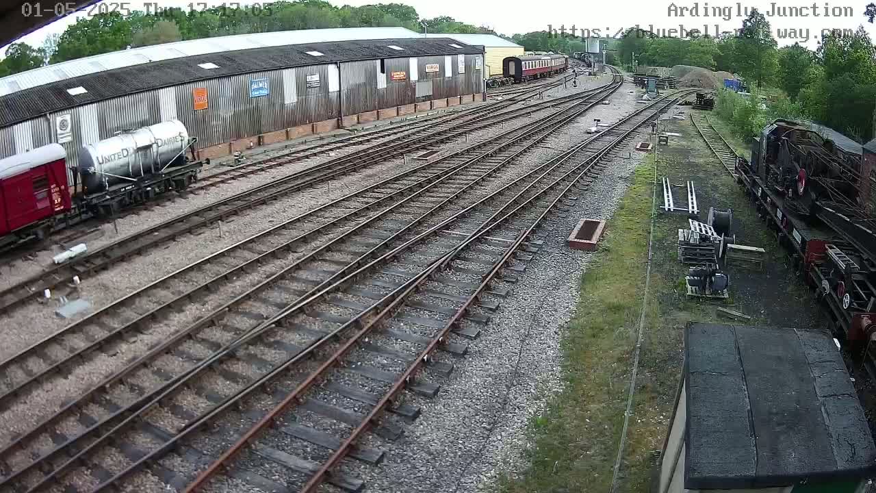 A railway yard with multiple train cars and tracks, under an overcast sky.
