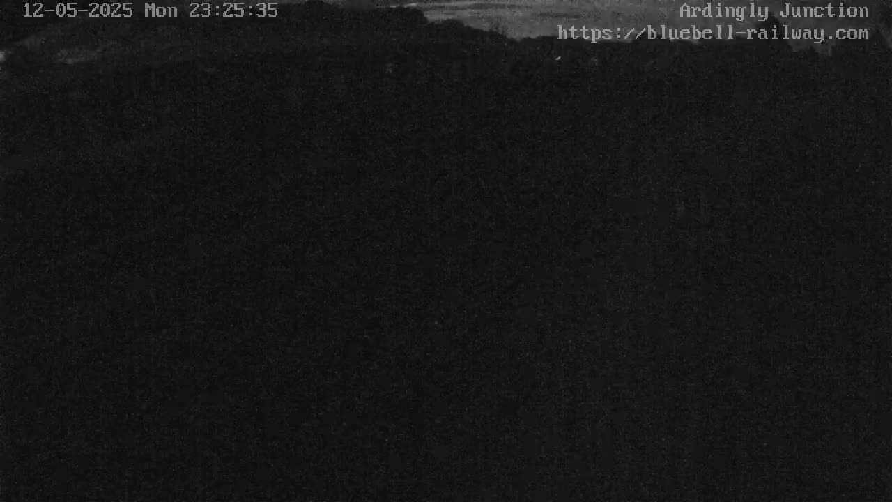 A dark, nighttime image shows a mostly obscured landscape under a dimly lit sky.