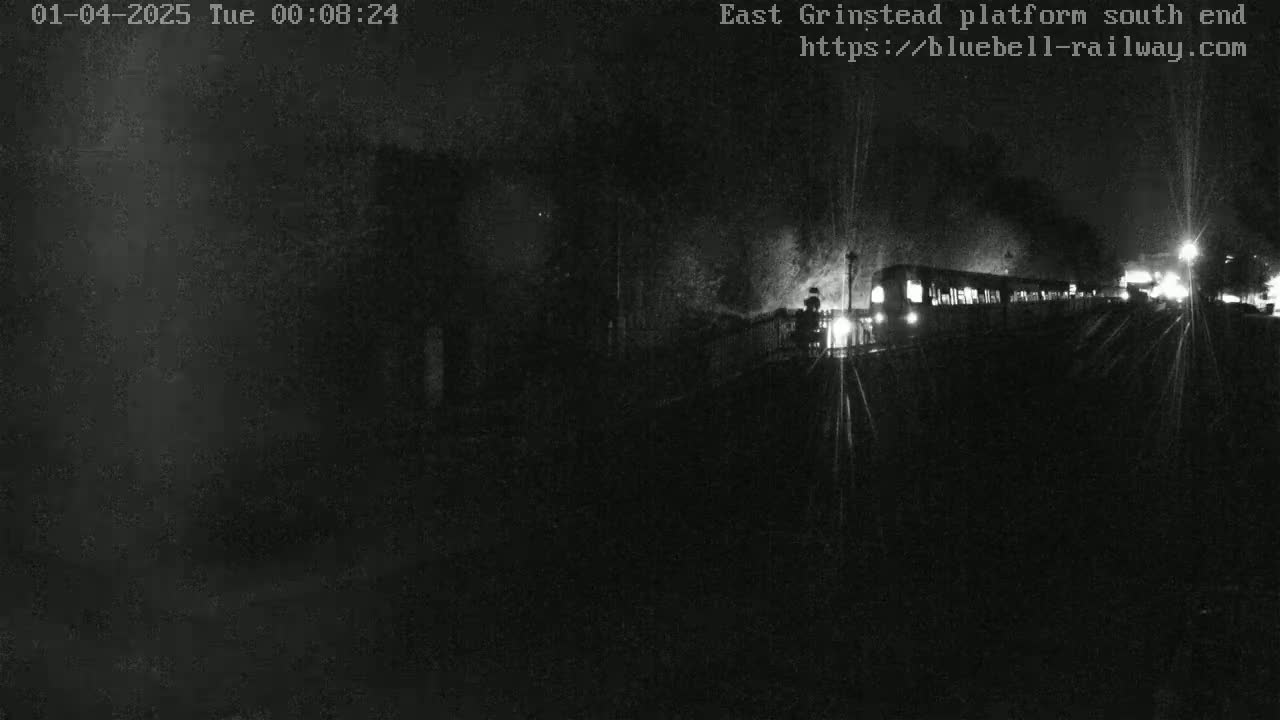 A dimly lit train passes by at night.