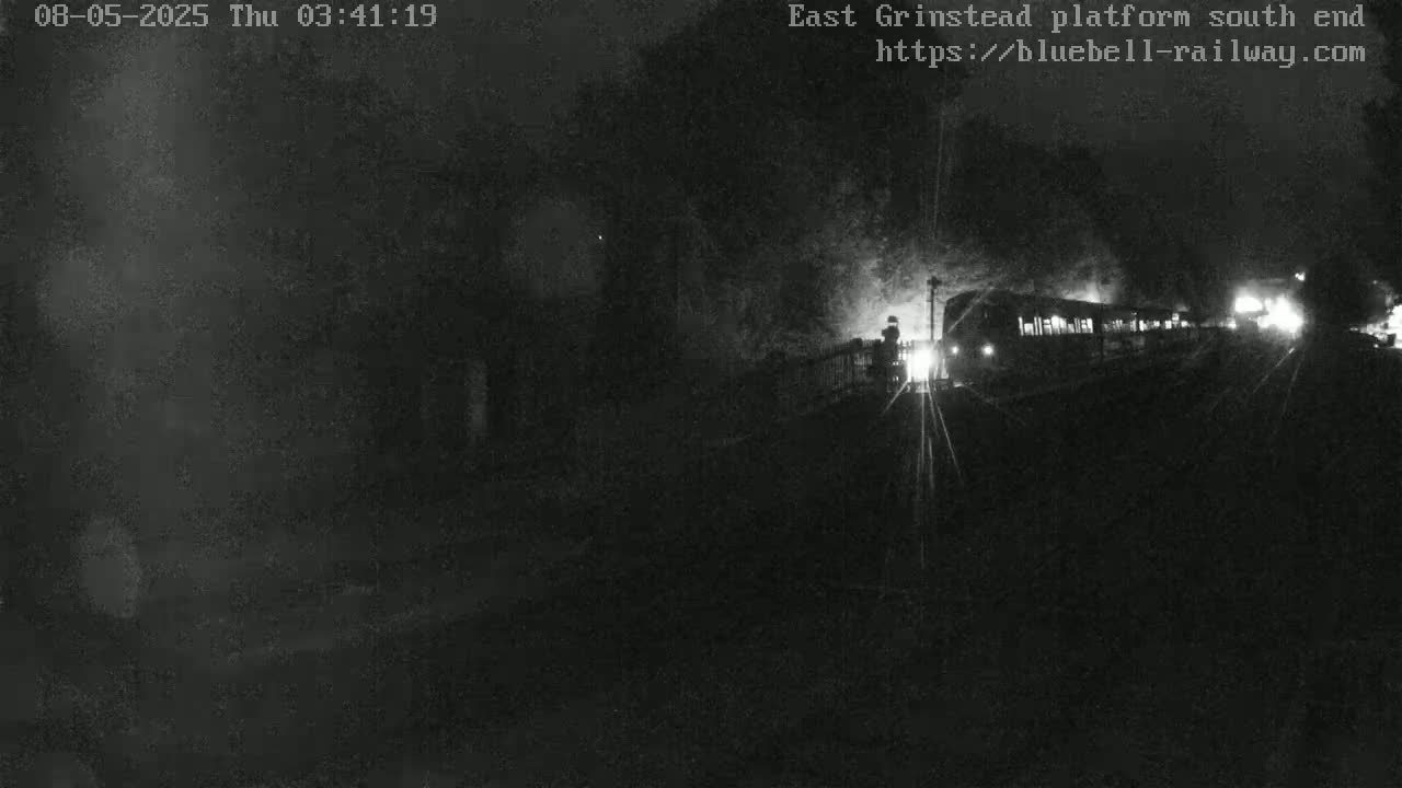 A dimly lit train departs from a station at night.