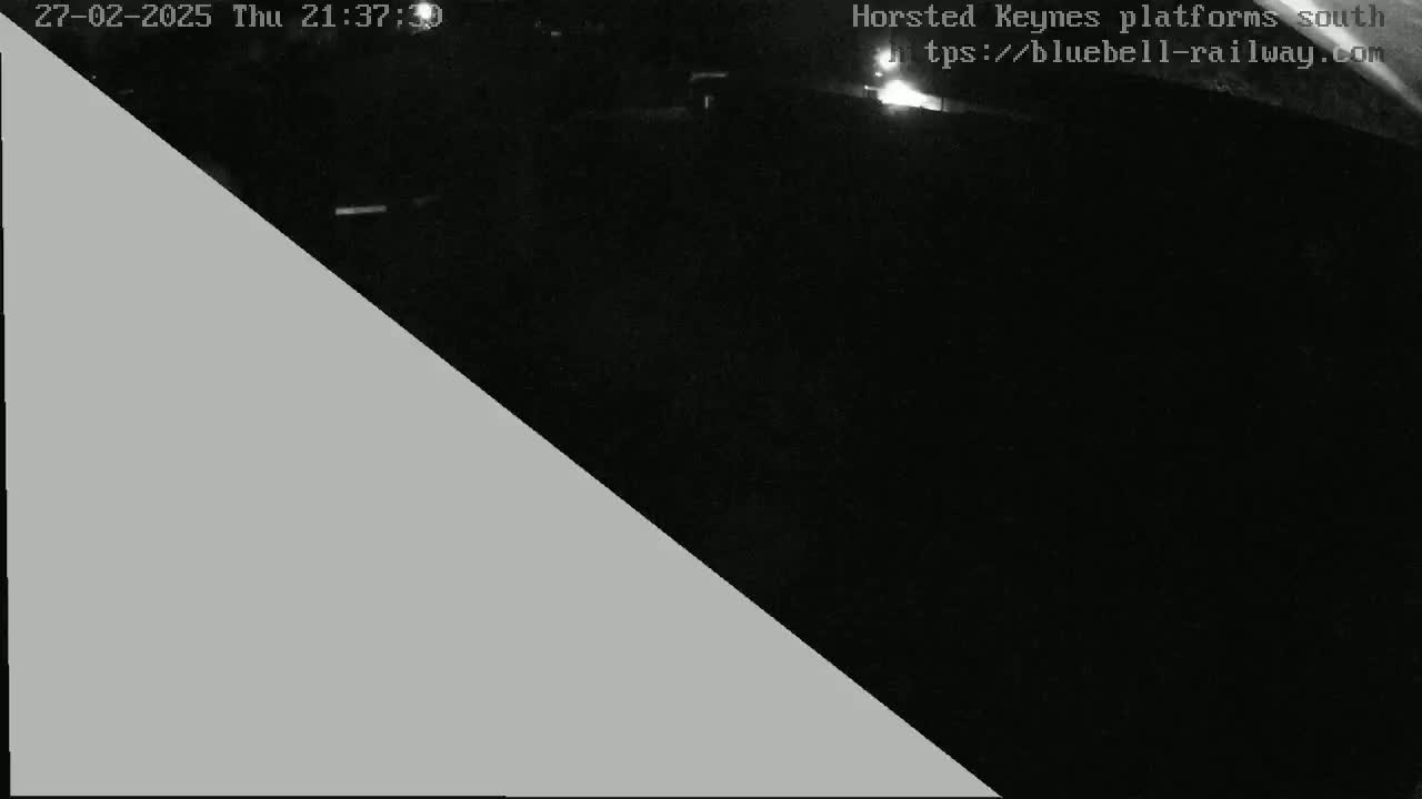 A nighttime, low-light image shows a dark, possibly outdoor scene, partially obscured by a large gray triangle covering the left side of the frame.