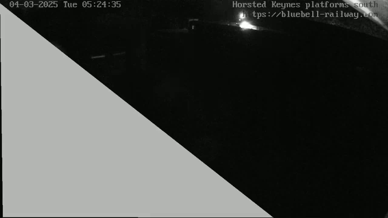 A nighttime, low-light image shows a mostly dark scene with a gray triangle obscuring part of the view.