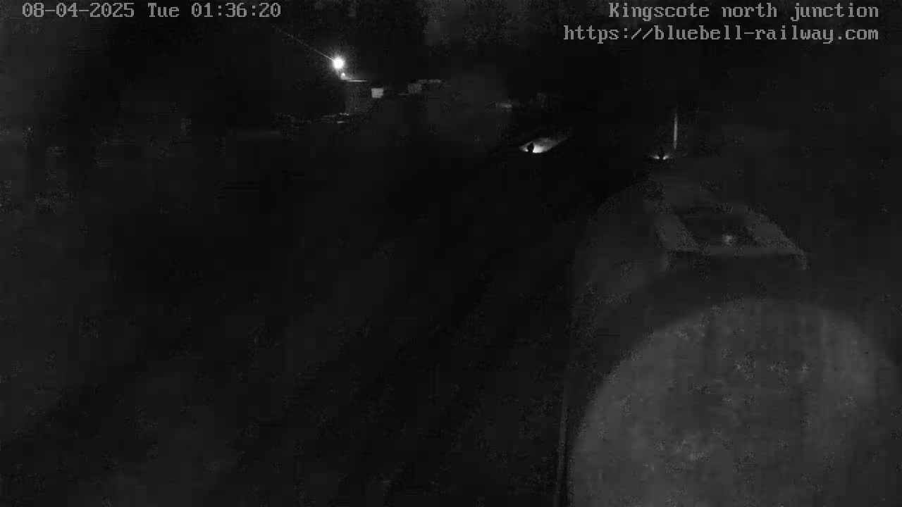 A nighttime, low-light view of a dark, mostly indistinct area, possibly outdoors.