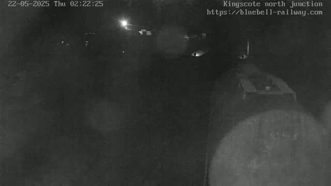 A nighttime, low-light view of a dark roadway or train yard.