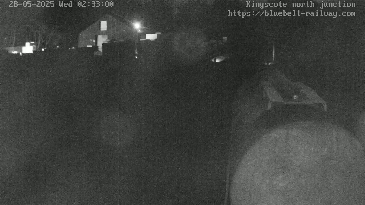 A nighttime, low-light view of a building and what appears to be a railway junction.