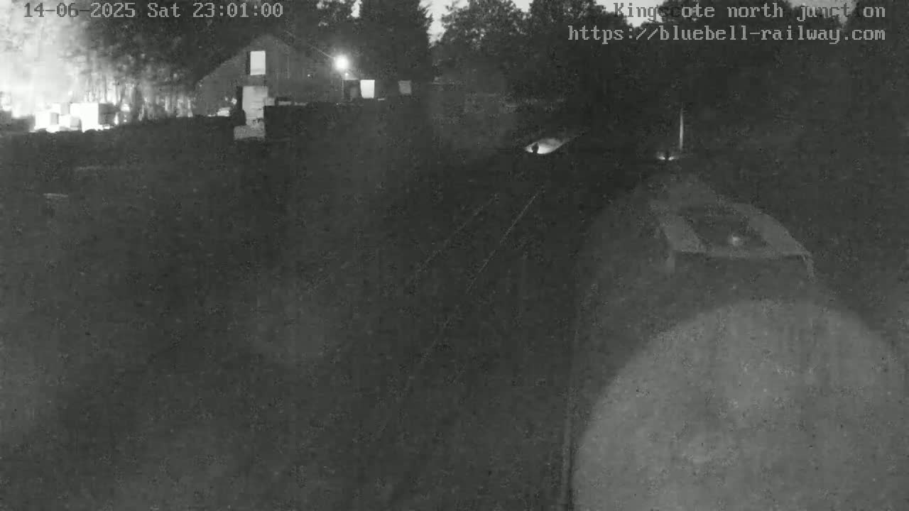 A nighttime, low-light view of a building and what appears to be a railway junction.