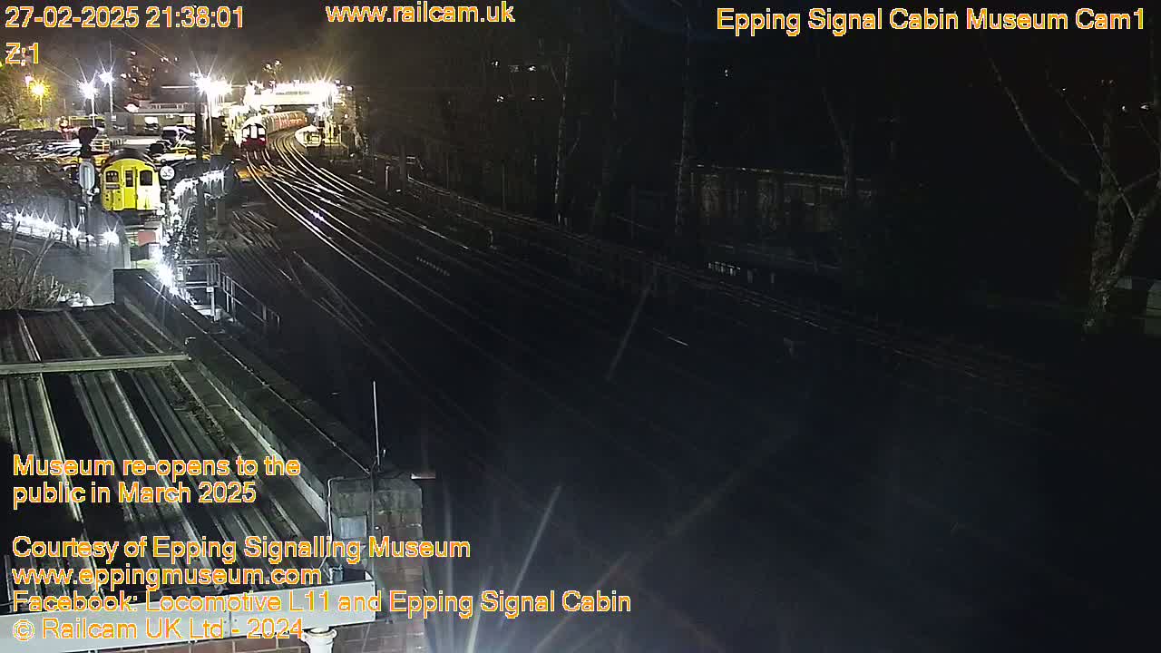 At night, a train sits in a dark railway yard illuminated by artificial lights.