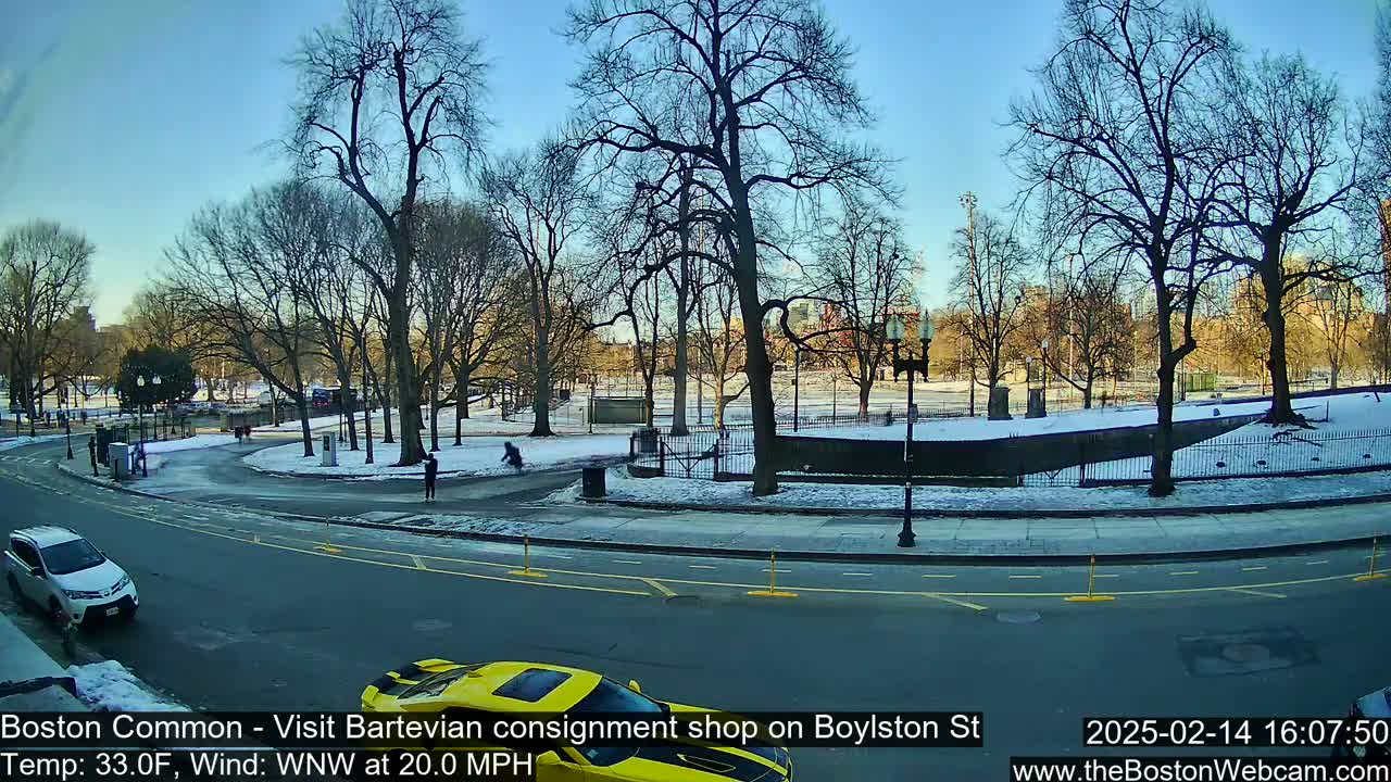 A partly sunny winter day shows a snow-covered park with bare trees, a street with cars, and a few pedestrians.