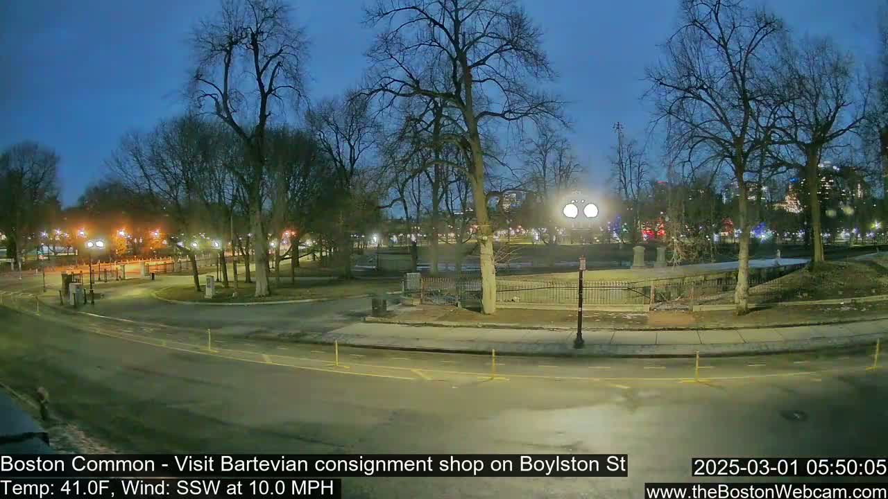 A nighttime view of a park with bare trees and illuminated pathways, under a twilight sky with a south-southwesterly wind of 10 mph and a temperature of 41 degrees Fahrenheit.