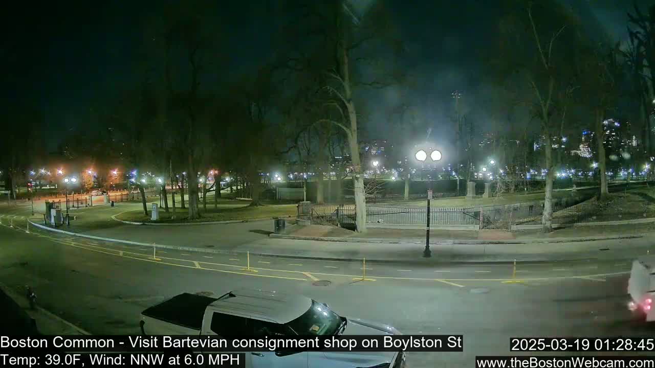 A nighttime view of a park with a road curving through it, under a dark sky with a 39°F temperature and a 6.0 mph north-northwest wind.