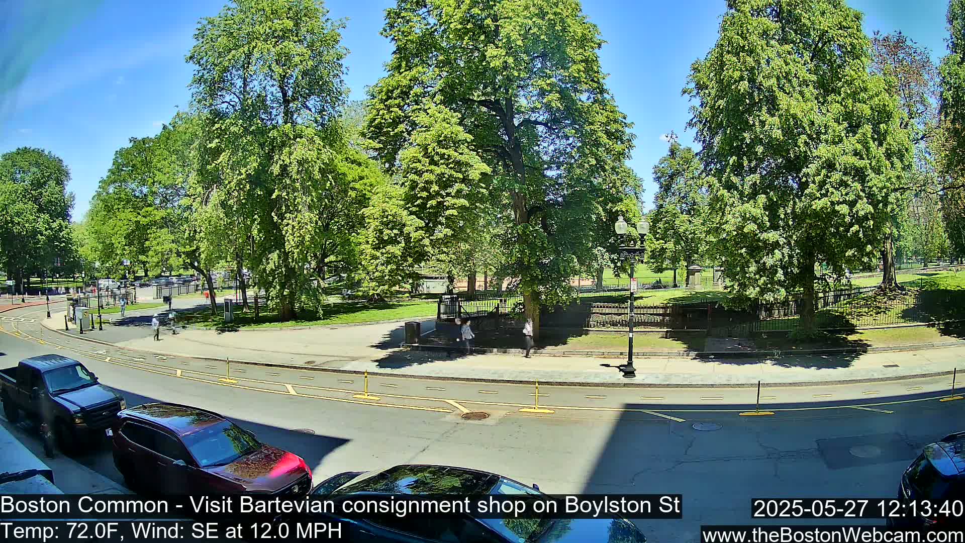 A sunny day with a southeast wind shows a street scene next to a park with lush green trees and a few pedestrians.