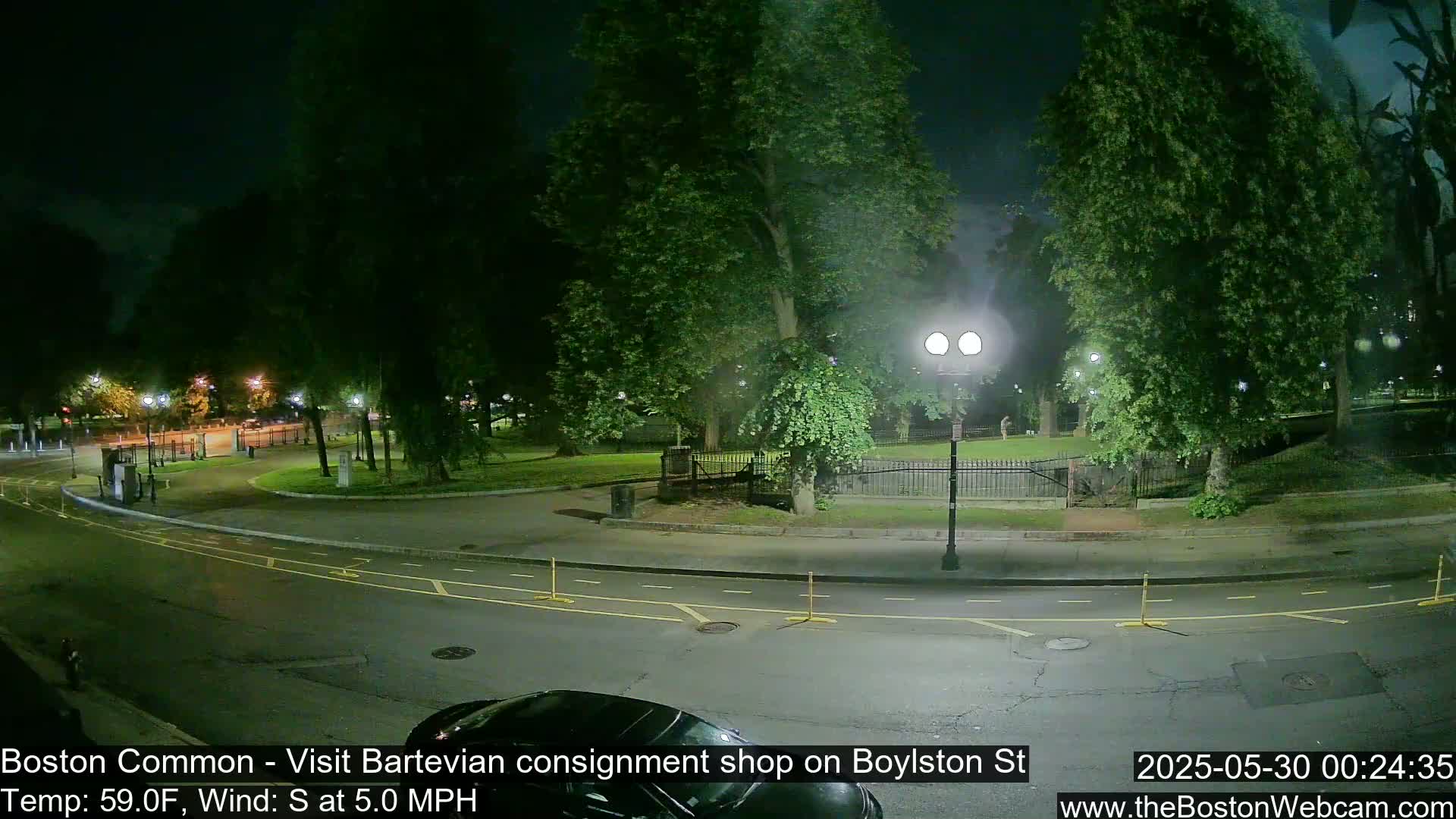 A nighttime street scene shows a park with trees and a roadway, under a partly cloudy sky with a light south wind.
