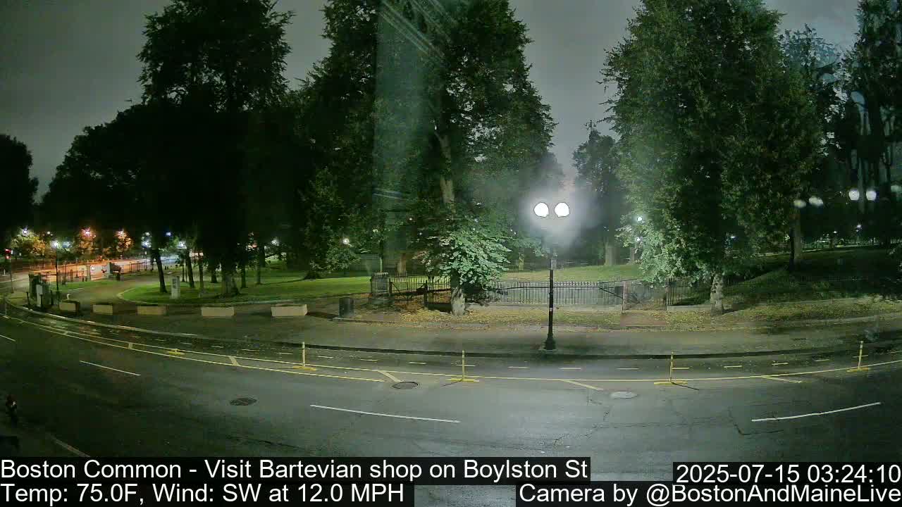 A nighttime view of a park and roadway, with a partly cloudy sky and a southwest wind at 12 mph.