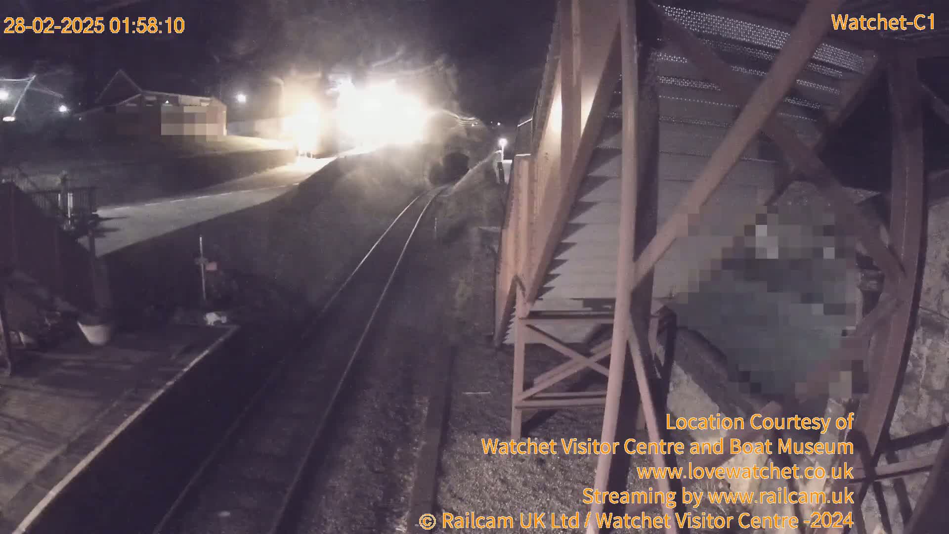 A brightly lit train passes through a tunnel at night.