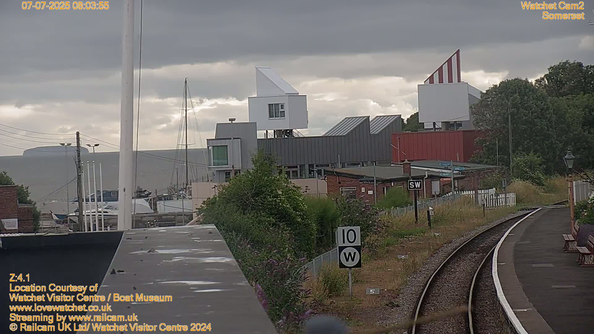 A view of a harbor with modern buildings under an overcast sky.