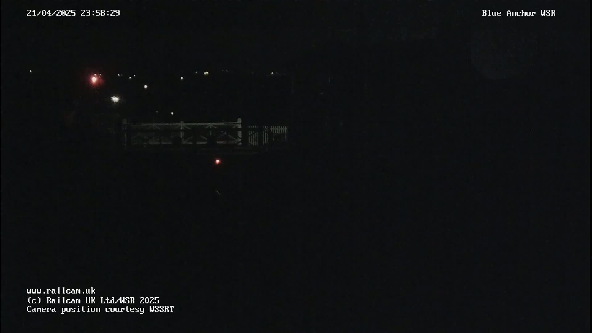 A nighttime view of a dimly lit bridge and distant lights.