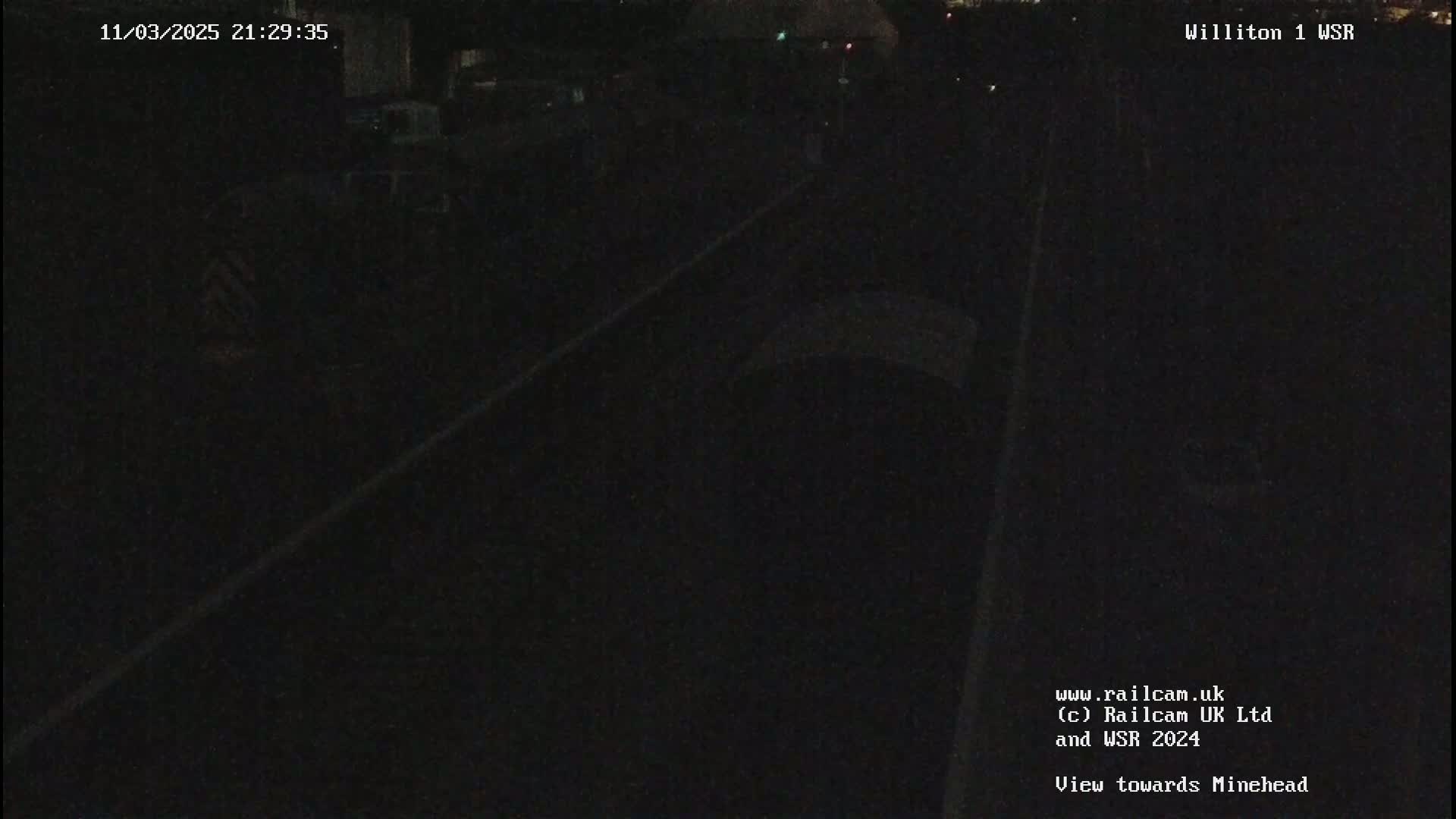 A dark nighttime view of a railway track.
