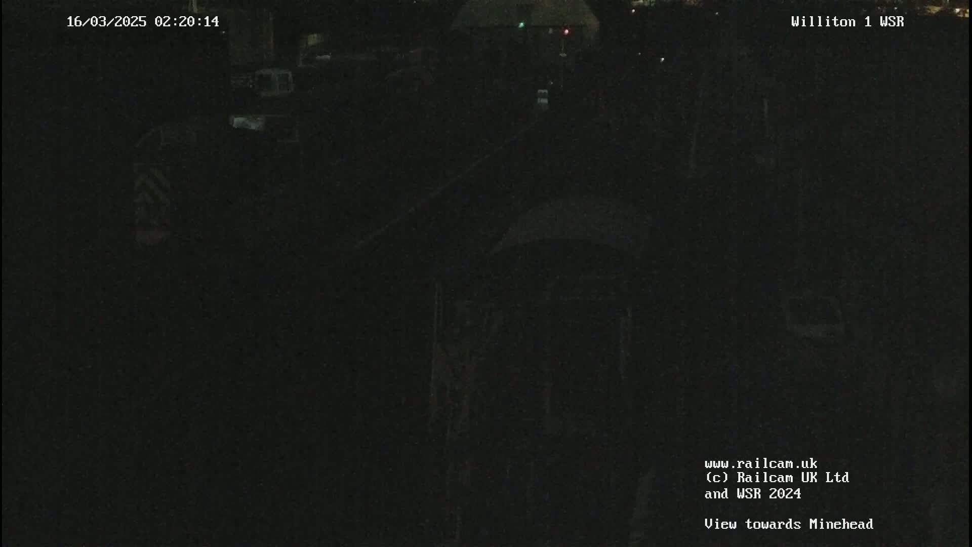 A dark, nighttime view of an indistinct scene, possibly a railway yard.