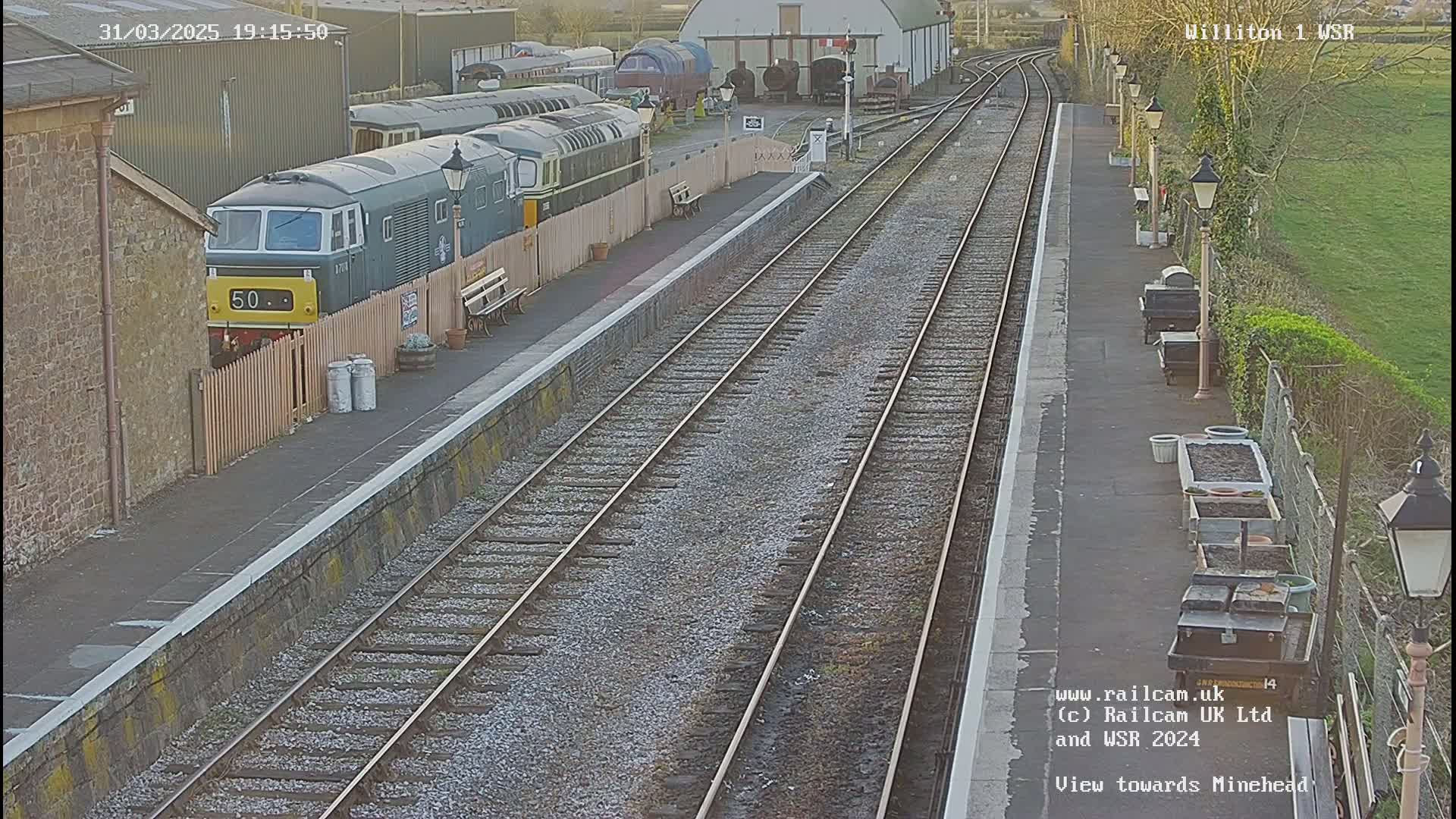 A train is parked at a railway station on a partly sunny day.