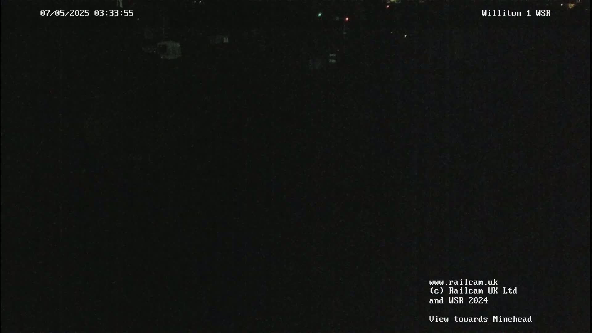 A nearly completely dark nighttime scene is visible, showing only faint lights in the far distance.
