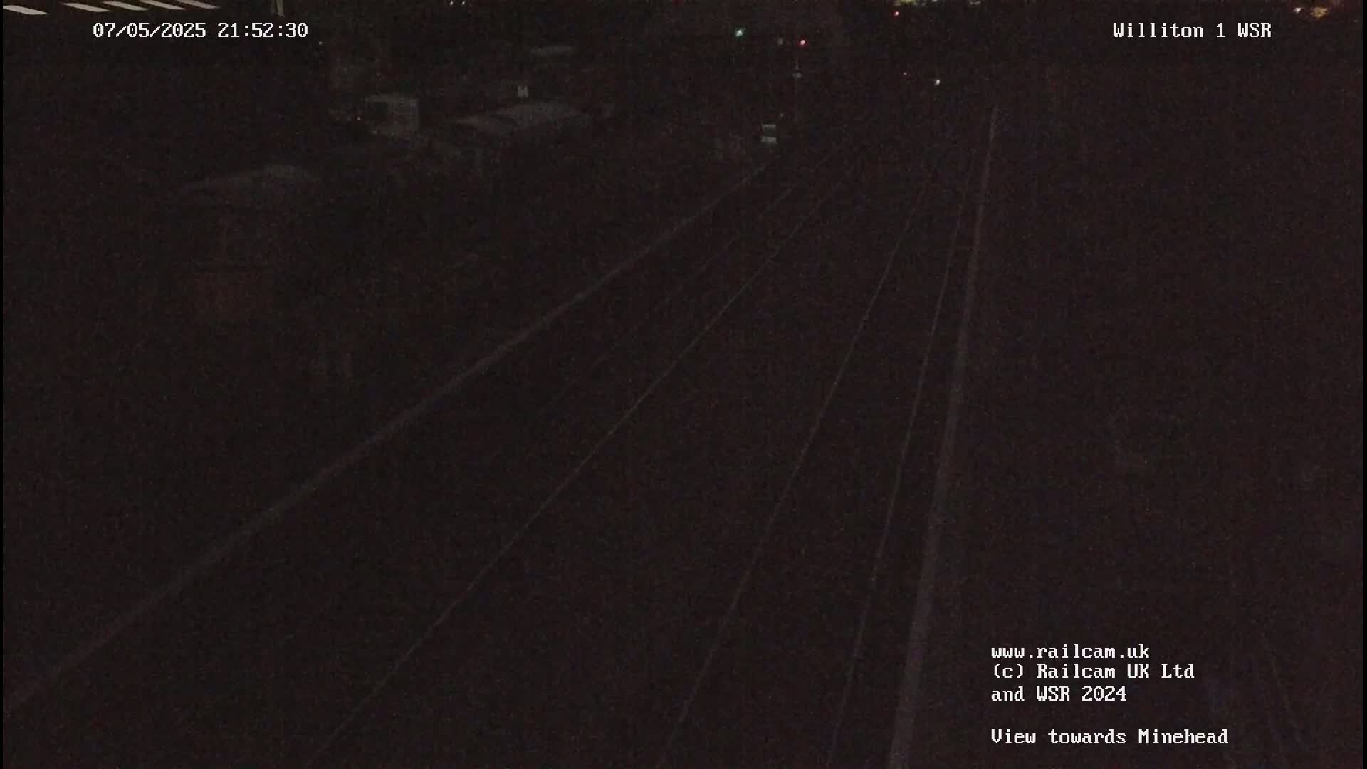 A dark nighttime view of train tracks extending into the distance.