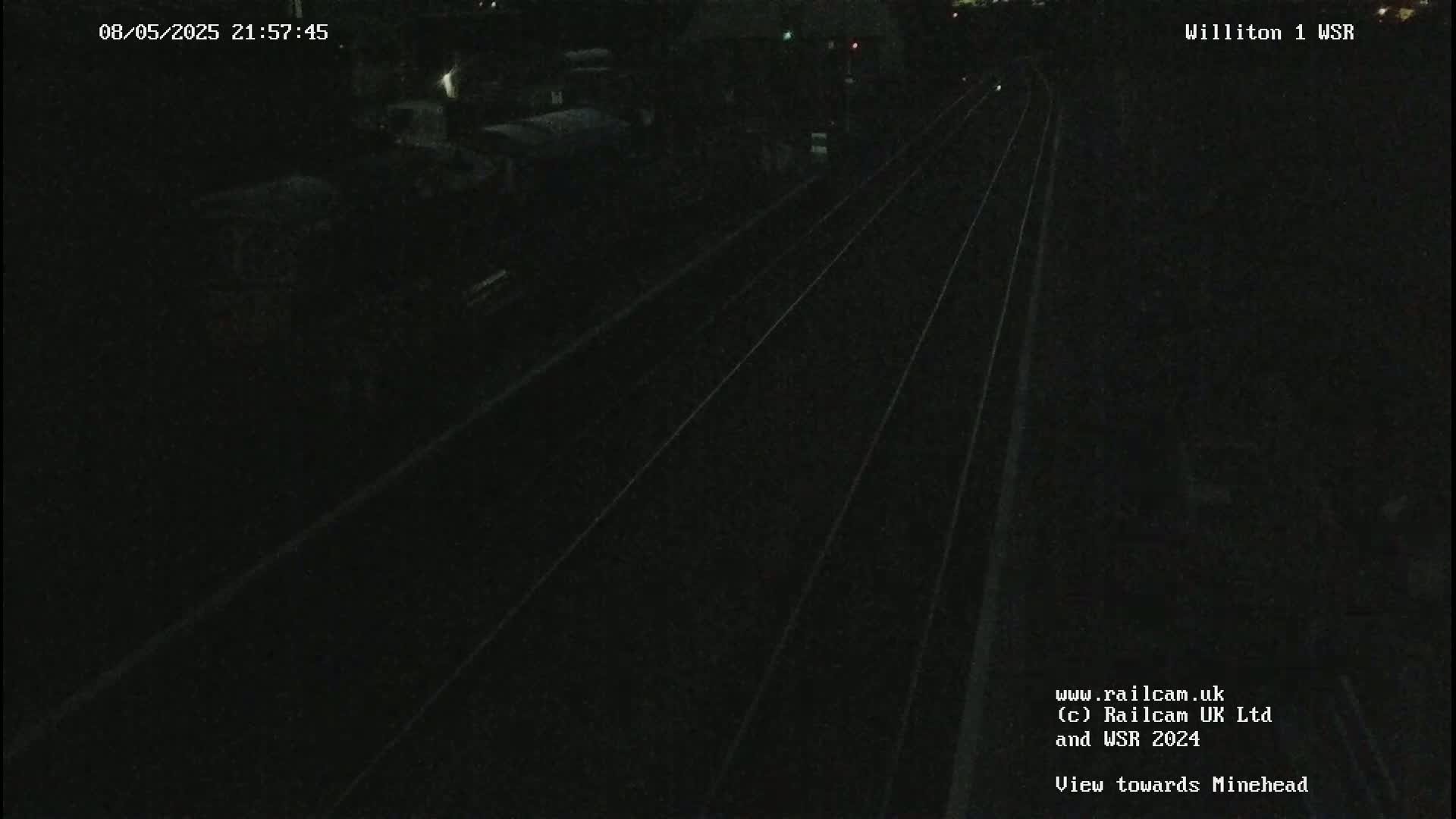 A nighttime view of dark train tracks extending into the distance.