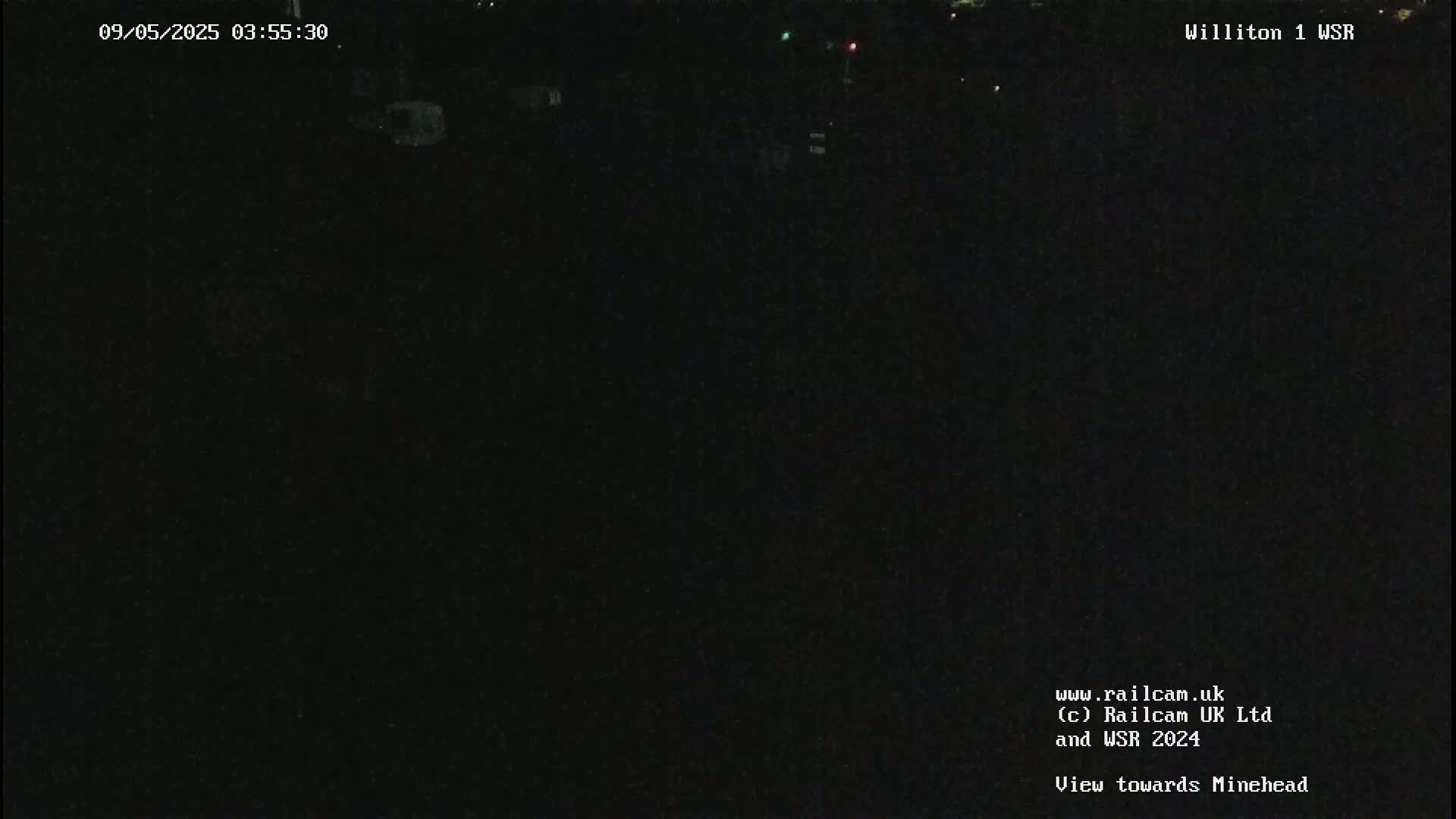 A dark, nighttime scene is visible, showing a mostly black field of view with a few indistinct shapes.