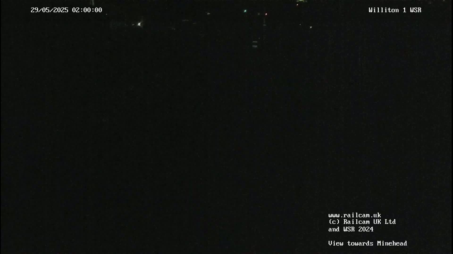 A nighttime, dark view of a landscape, possibly from a security camera, showing little to no detail.