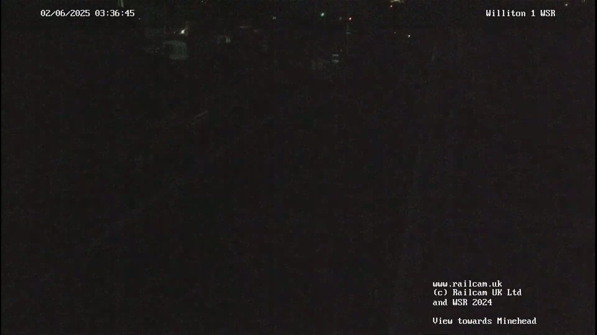 A nighttime, dark view of an area, possibly a field or road.