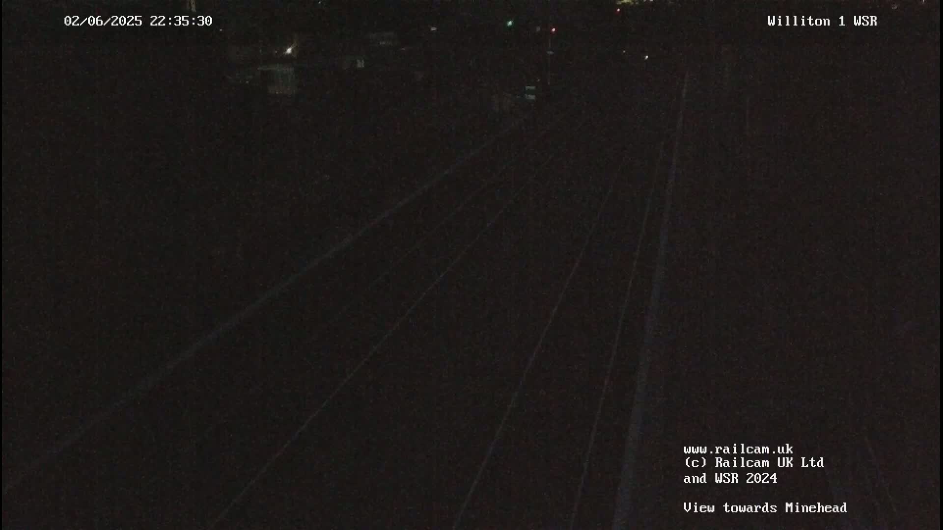 A nighttime, dark view of train tracks.