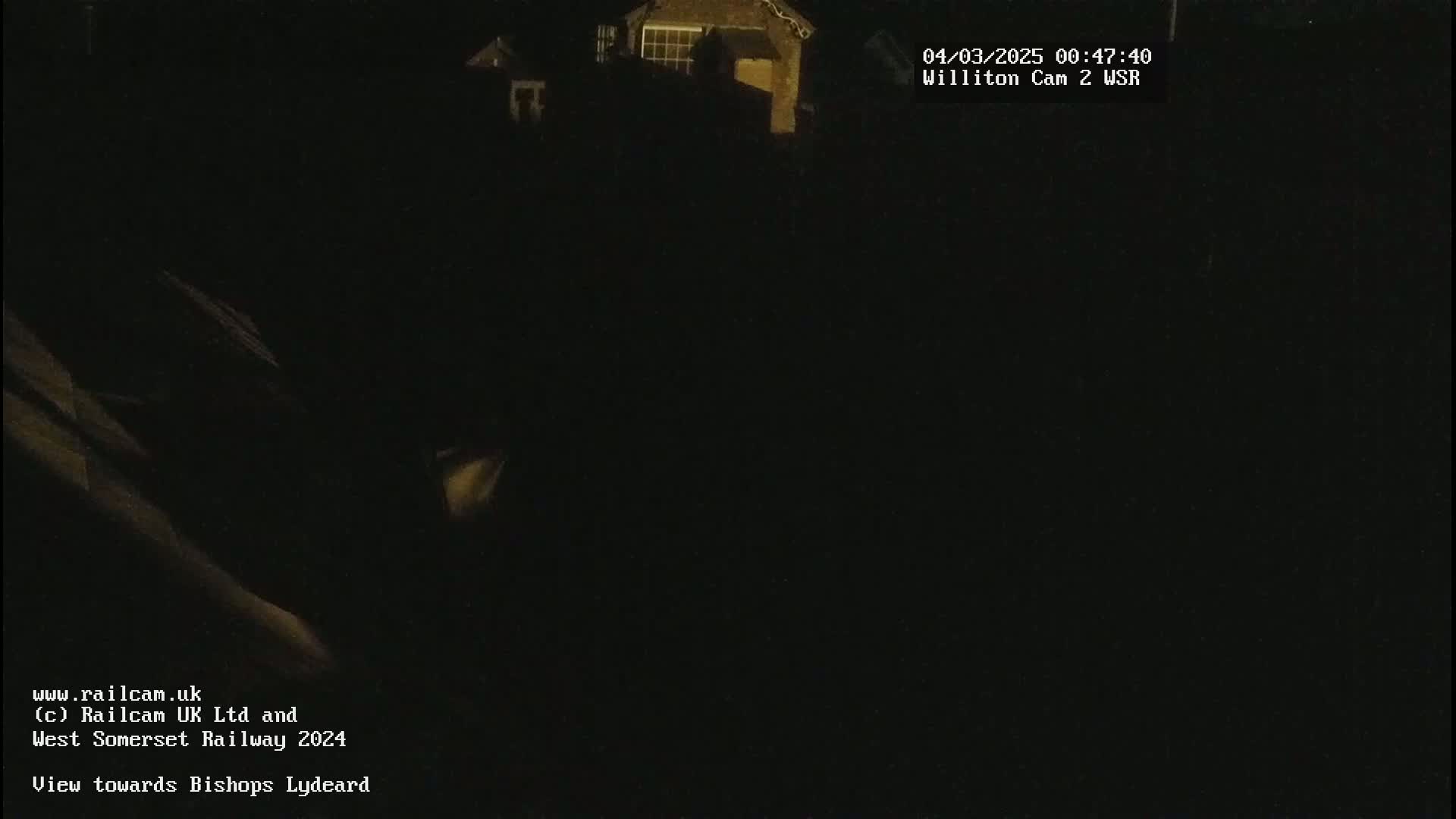 A dimly lit, nighttime outdoor scene shows a building in the distance.