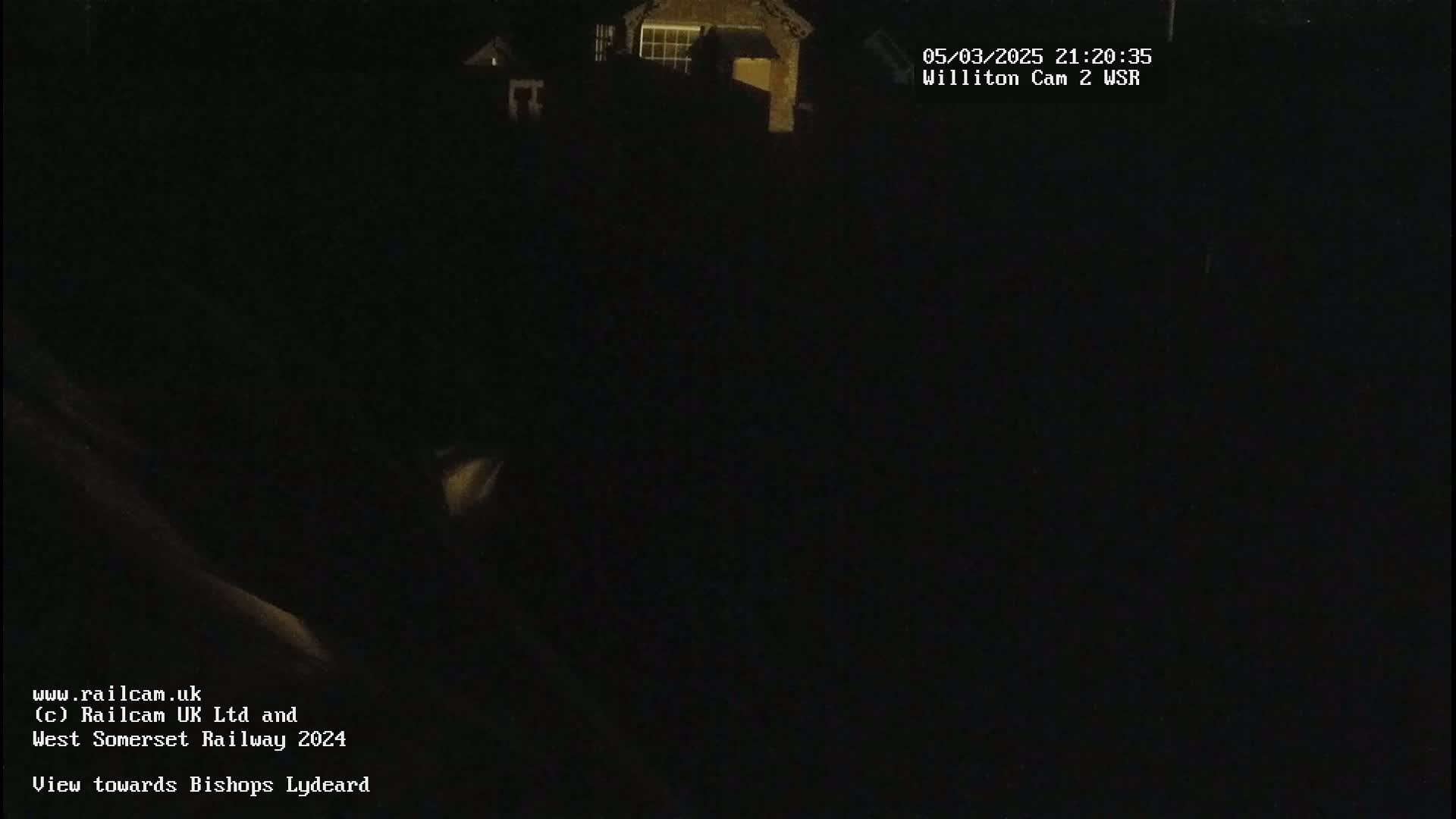 A dark, nighttime view of a building is seen from a distance.