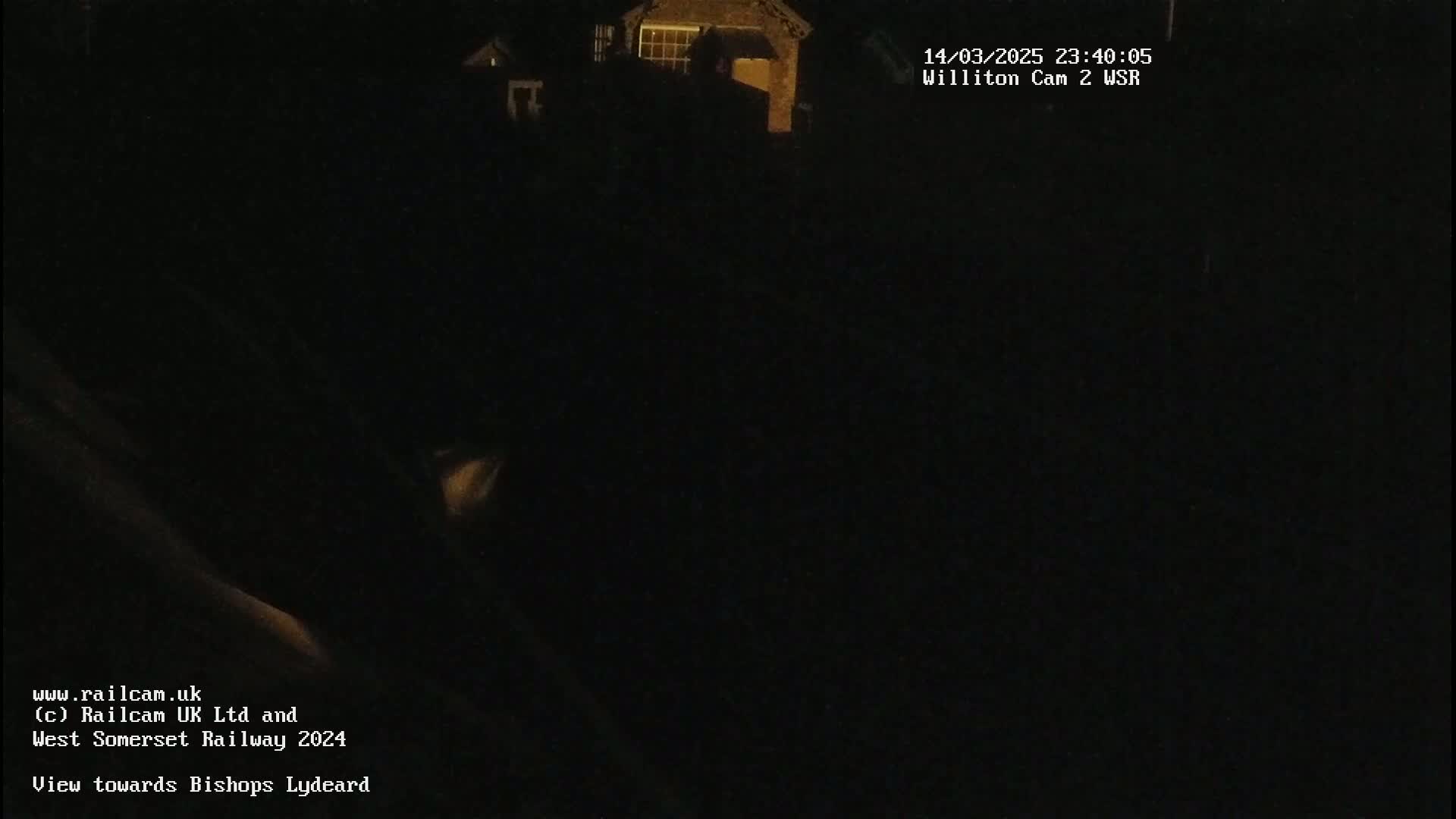 A nighttime, dark view of a building is visible in the distance.