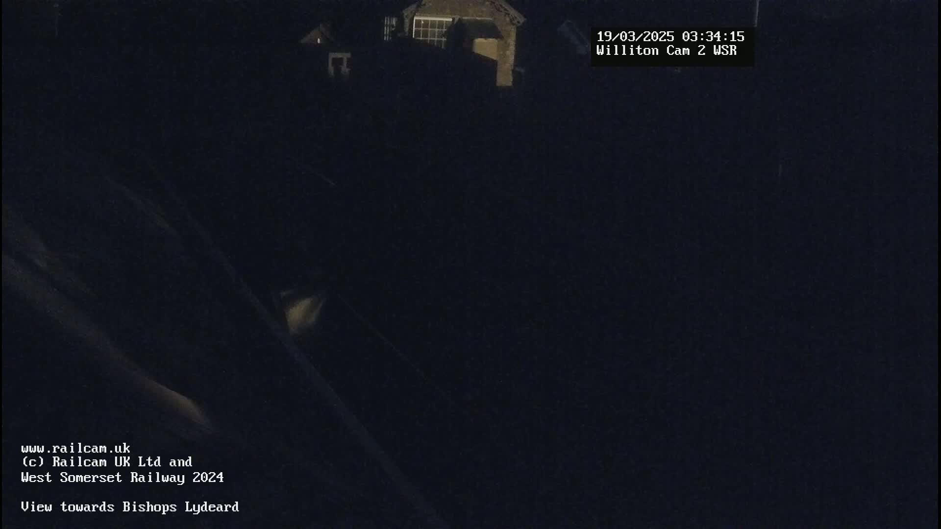 A dark, nighttime view of buildings in the distance.