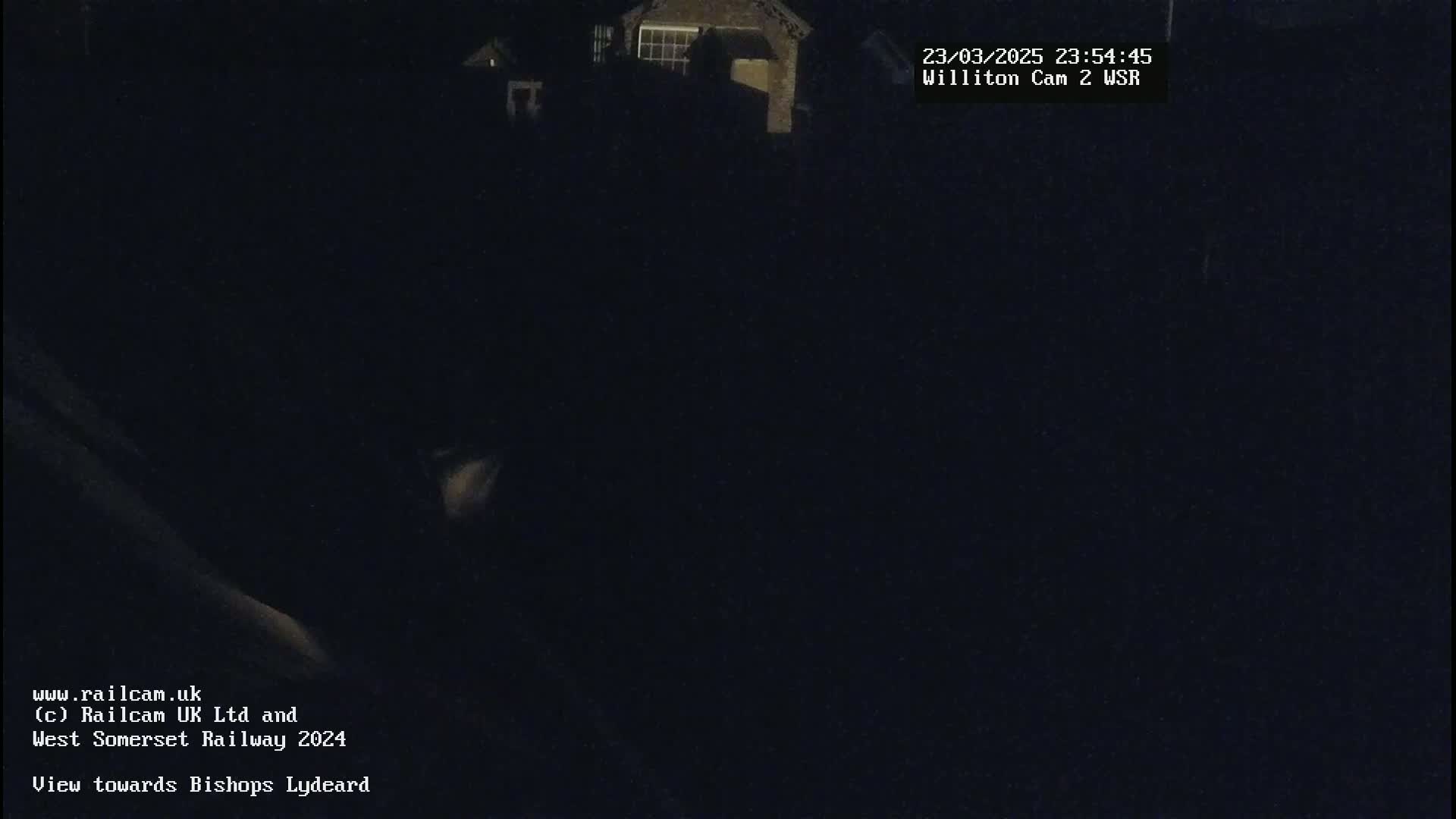 A nighttime, dark view of a building and surrounding area under a clear sky.