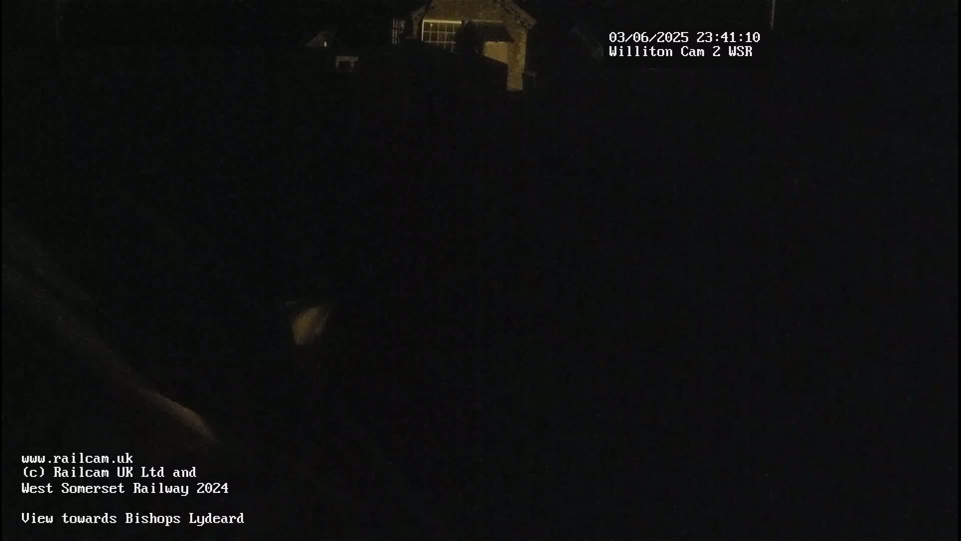 A nighttime, dark view of a building is seen from a low angle.