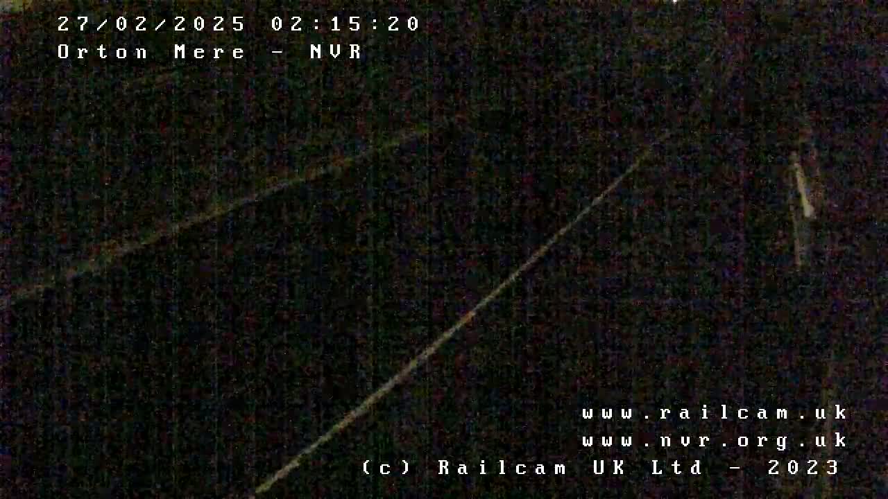 A nighttime, low-light view of what appears to be railroad tracks.