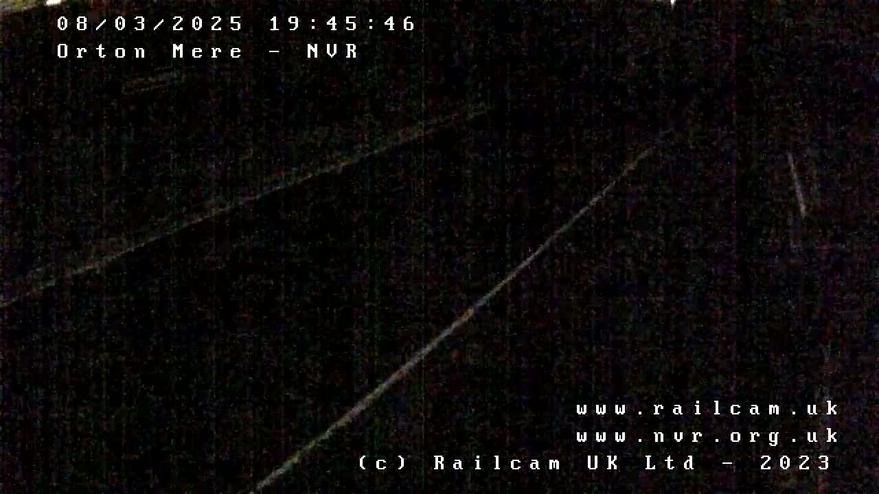 A dark, nighttime view of a railway line.