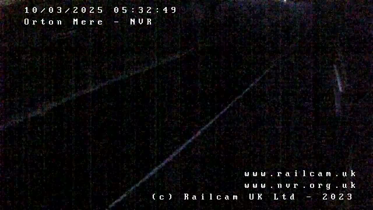 A dark, nighttime view of what appears to be a railway line.