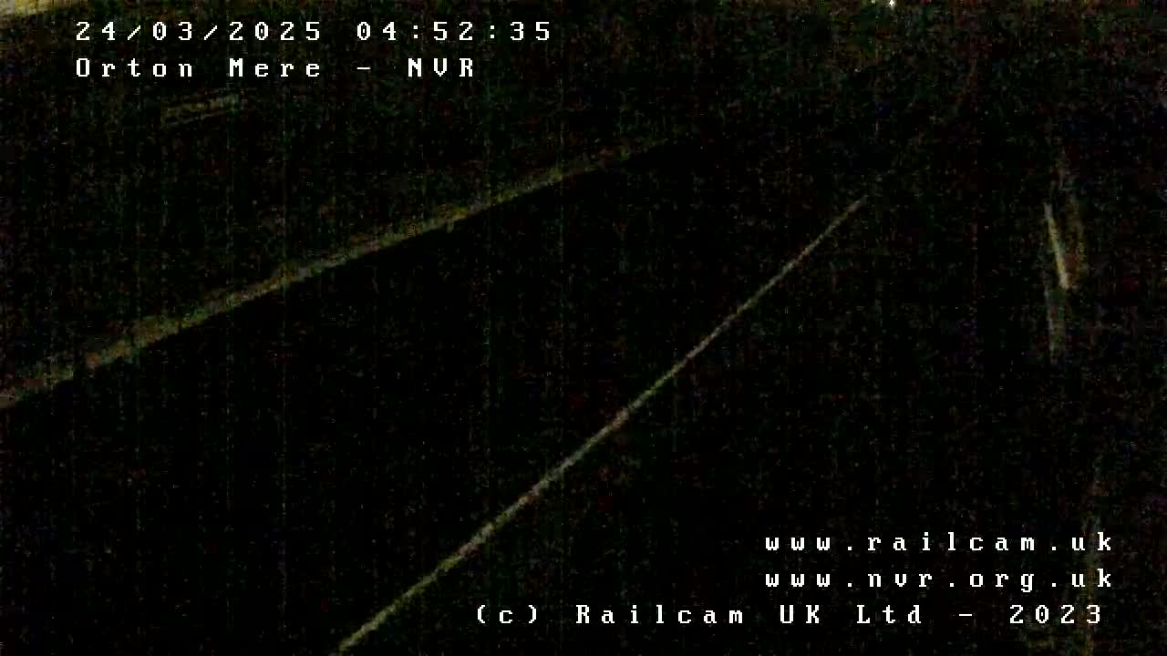 A dark, nighttime view of two parallel lines, possibly railroad tracks, extending into the distance.