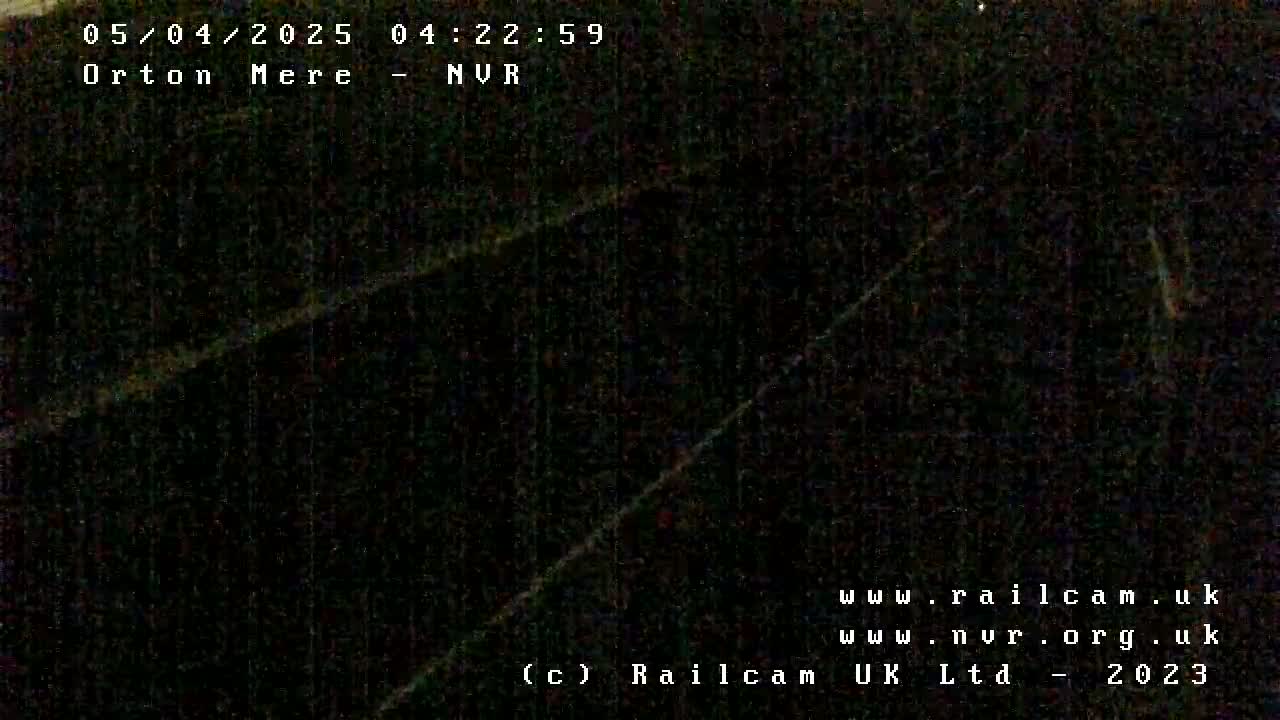 A dark, nighttime image shows a blurry, indistinct view of an outdoor scene.