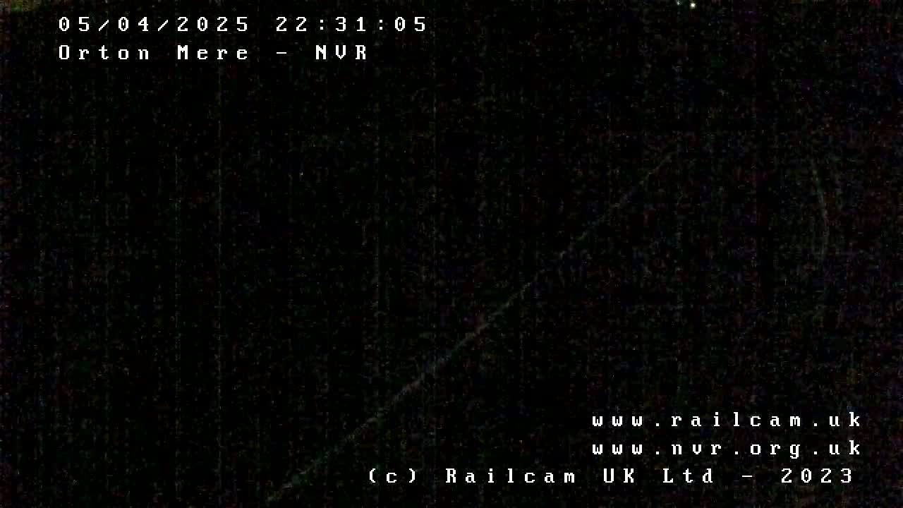 A nearly entirely black image, possibly taken at night, shows a faint, diagonal line of light.