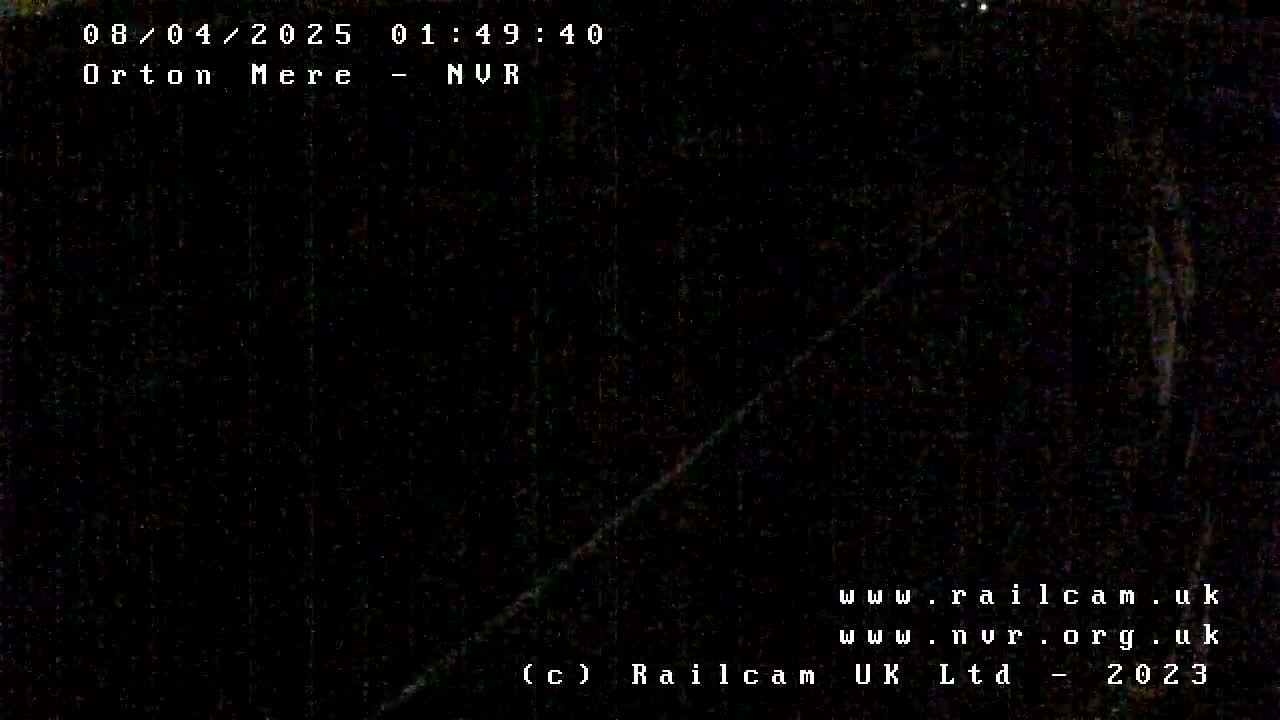 A dark, nighttime image shows a faint diagonal line across a mostly black background.