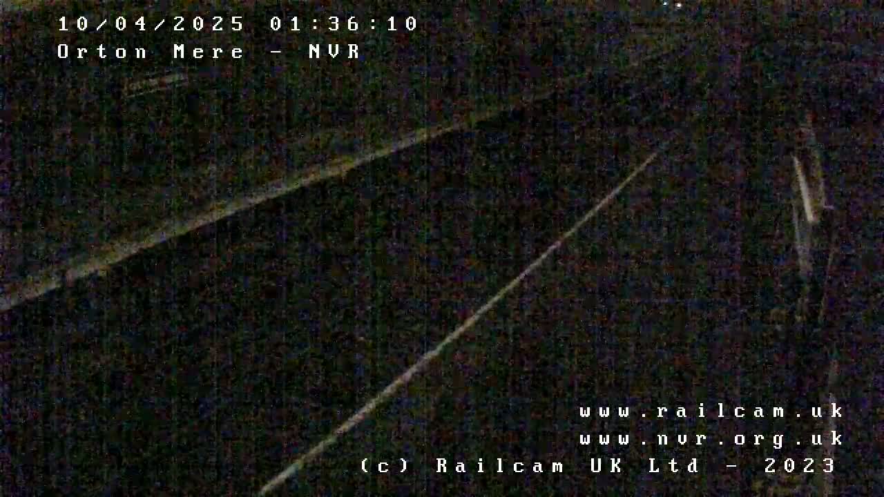 A dark nighttime view of railroad tracks.