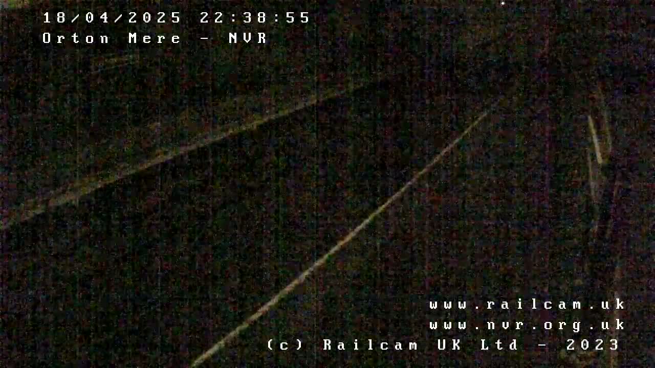 A nighttime, low-light view of a dark railway track.