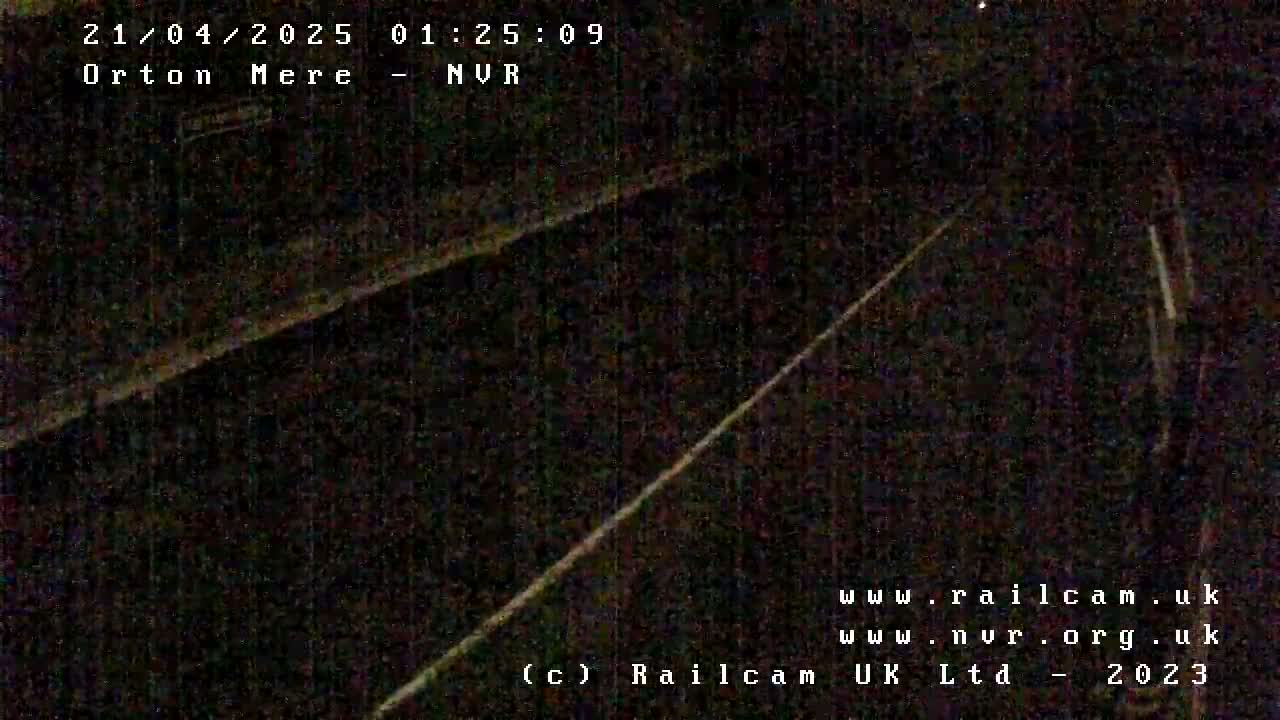 A dark, nighttime view of train tracks.