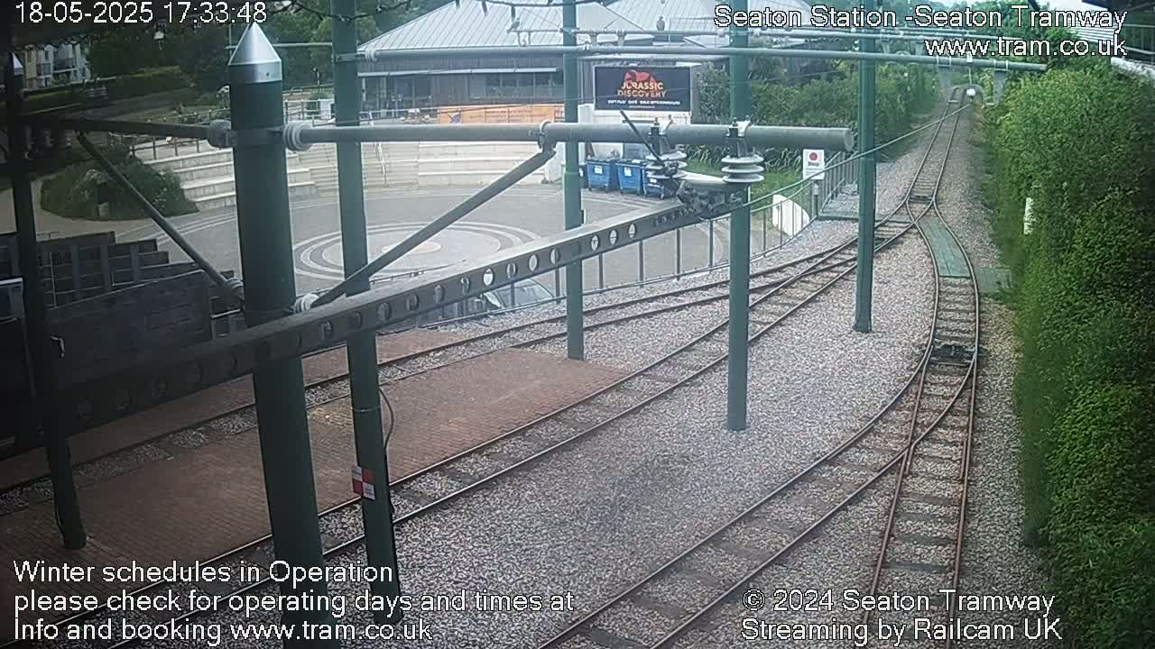 A high-angle view of a tram station's track system and surrounding area on an overcast day.